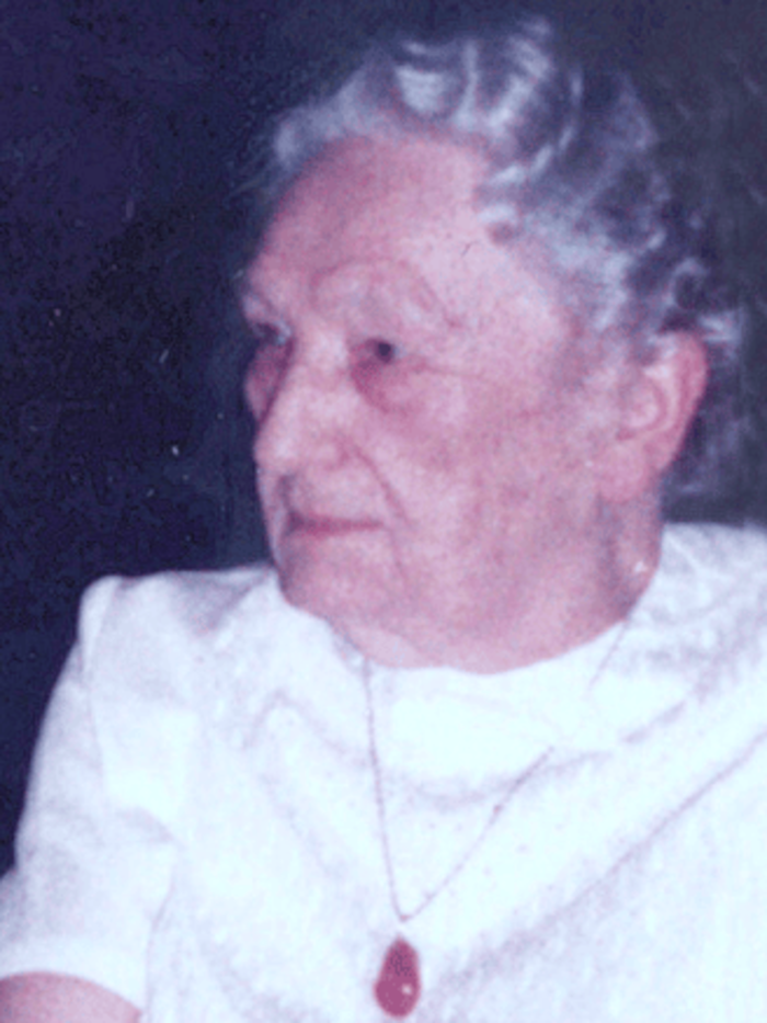 Zu sehen ist ein Porträt von Antoinette Adam im Seniorenalter. Sie trägt eine Halskette mit einem Anhänger um den Hals und blickt zur linken Seite.